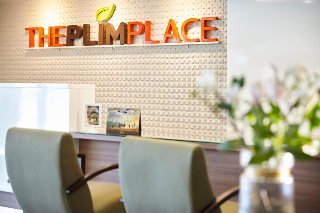 Bang Su的住宿－The Plimplace Hotel，一间设有两把椅子和阅读手语标志的餐厅