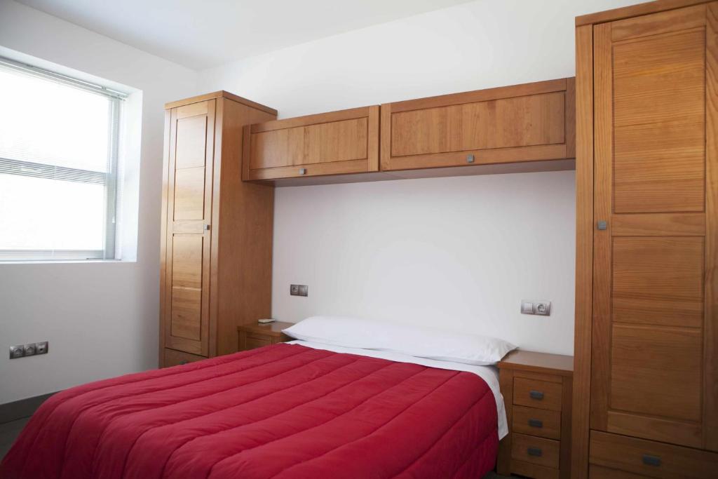 a bedroom with a bed with a red blanket at Casa Vagón Vía Verde de la Sierra in Olvera