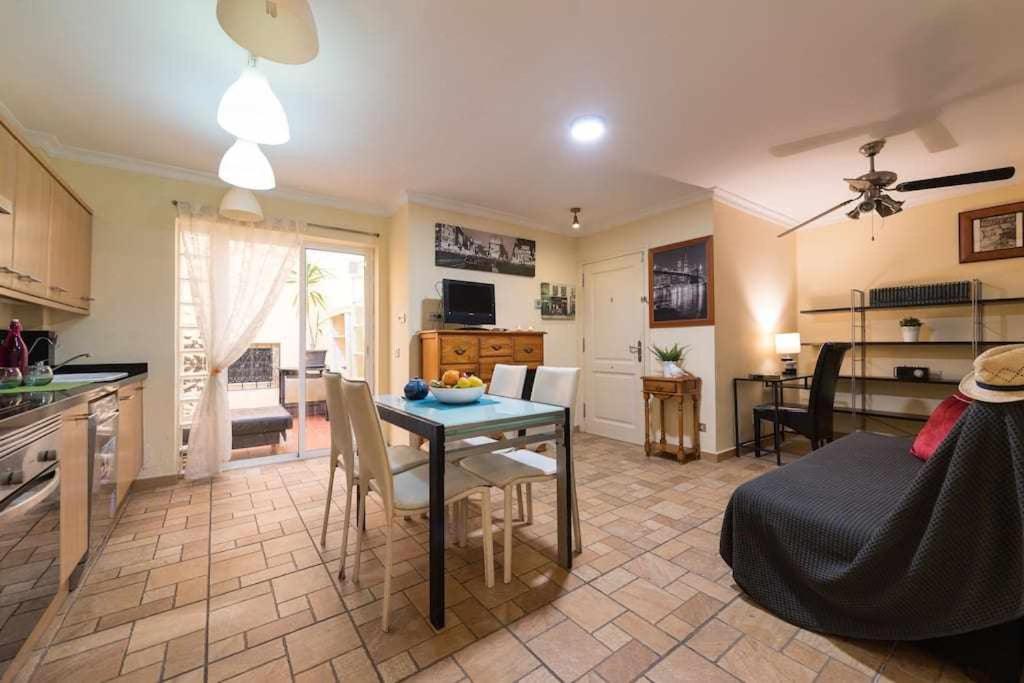 eine Küche und ein Wohnzimmer mit einem Tisch und einem Sofa in der Unterkunft MCD Carlos Family House in Las Palmas de Gran Canaria