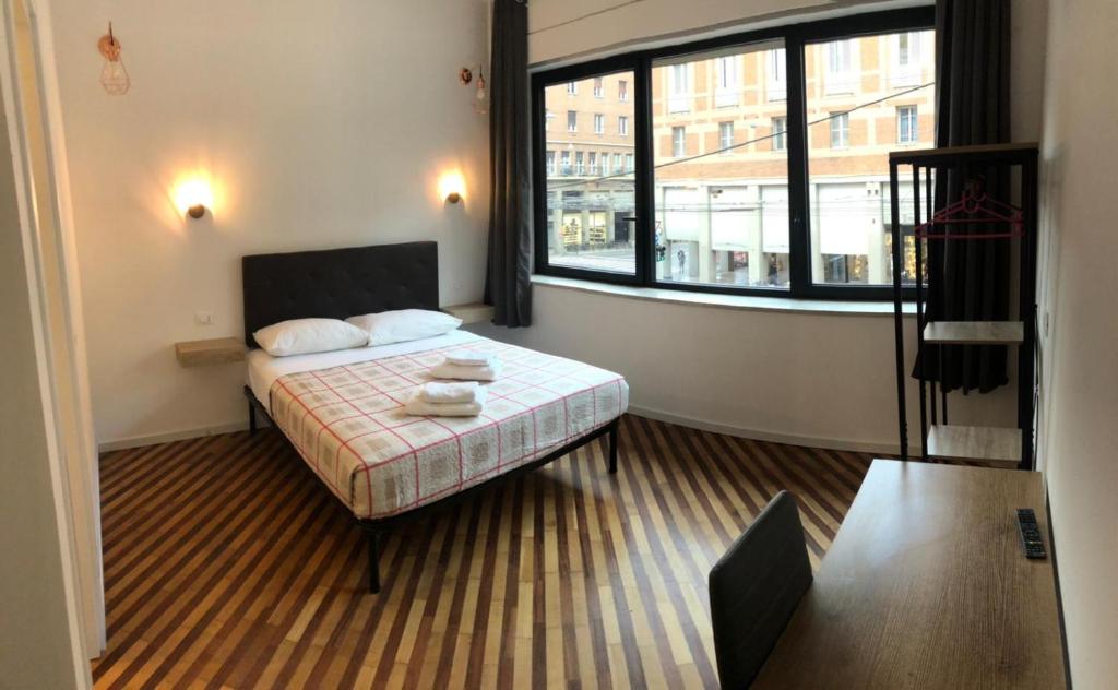 um quarto com uma cama e uma grande janela em GALLERIA DEL TORO 3 rooms em Bolonha