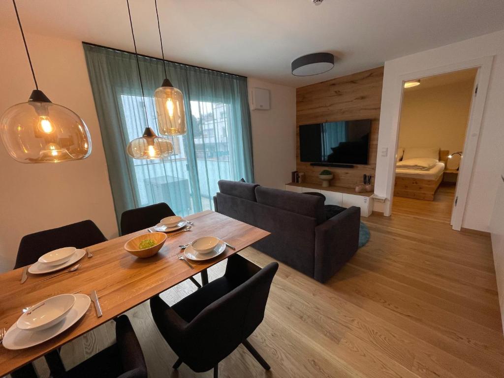 a dining room with a table and a couch at Planai Apartment Eishöhle in Schladming