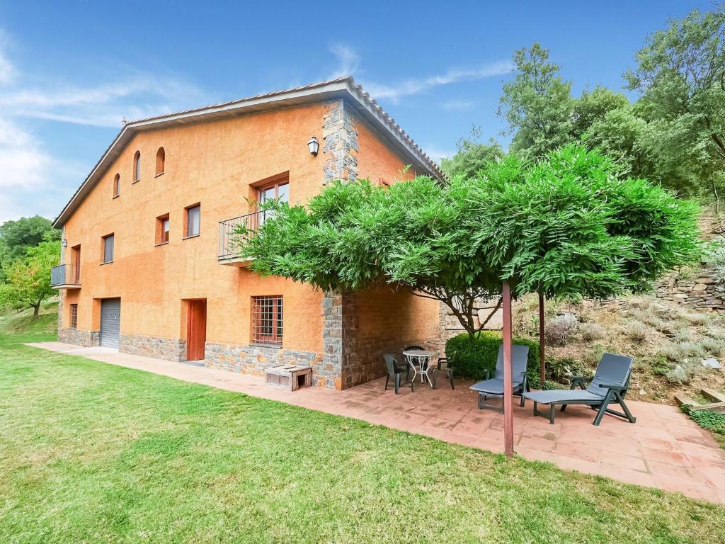 una casa de ladrillo naranja con un árbol delante de ella en Holiday Home Montseny with Pool, en Montseny