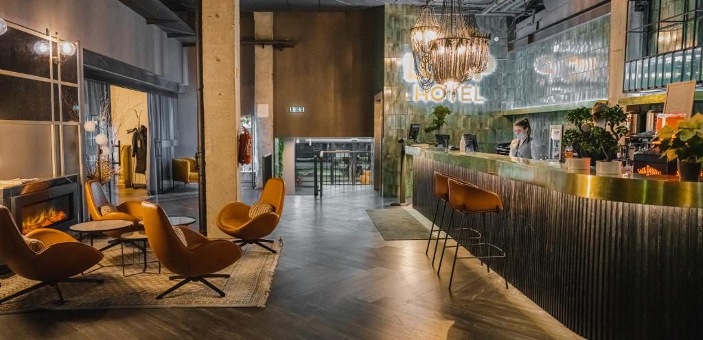 a living room filled with chairs and tables at Loop Hotel Vilnius in Vilnius