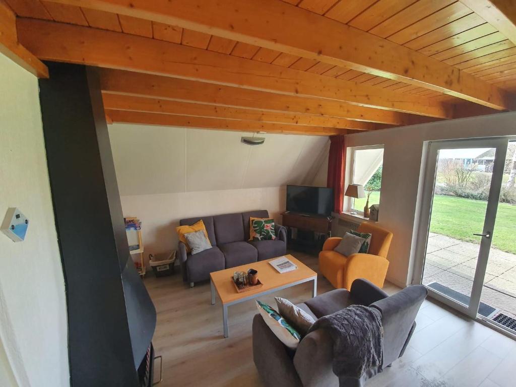 uma sala de estar com um sofá e uma mesa em Nice holiday home in Gramsbergen on family park em Gramsbergen