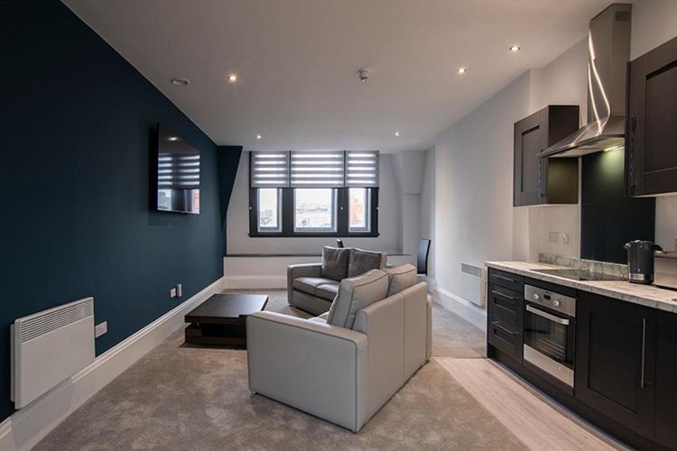 a living room with a couch and a kitchen at Cavern Quarter apartments by The Castle Collection in Liverpool