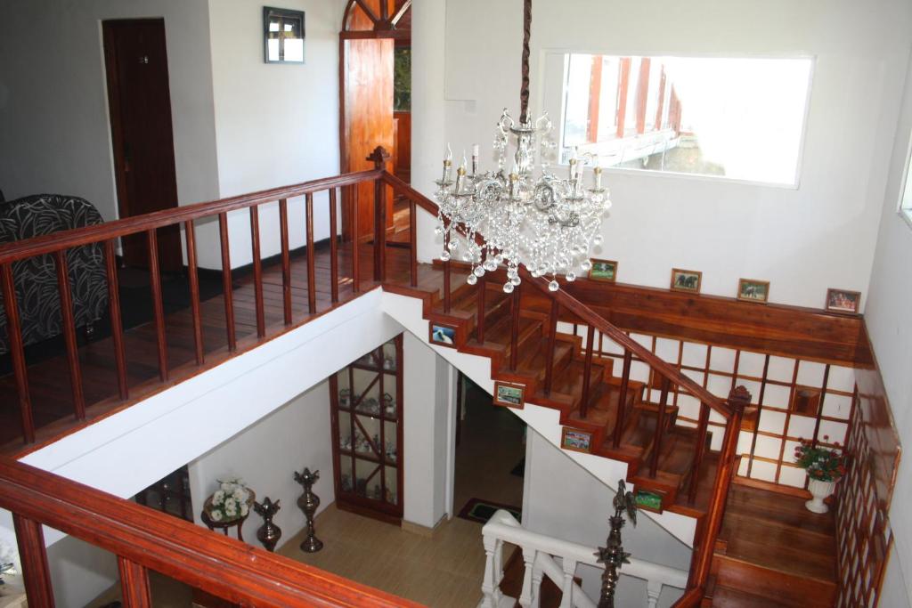 a staircase in a home with a chandelier at Bezel Bungalow Nuwara Eliya in Nuwara Eliya
