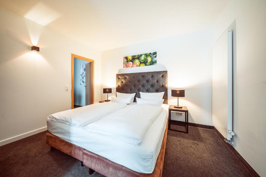 een slaapkamer met een groot bed met witte lakens bij Familienapartment Am Neumarkt ll in Dresden