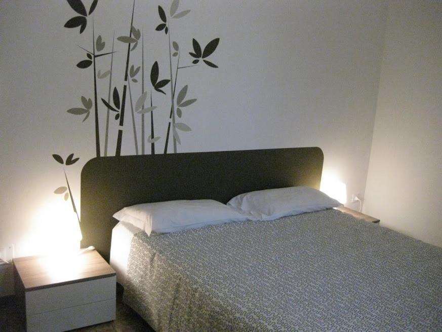 a bedroom with a bed with a plant on the wall at Low Cost Ferrara in Ferrara