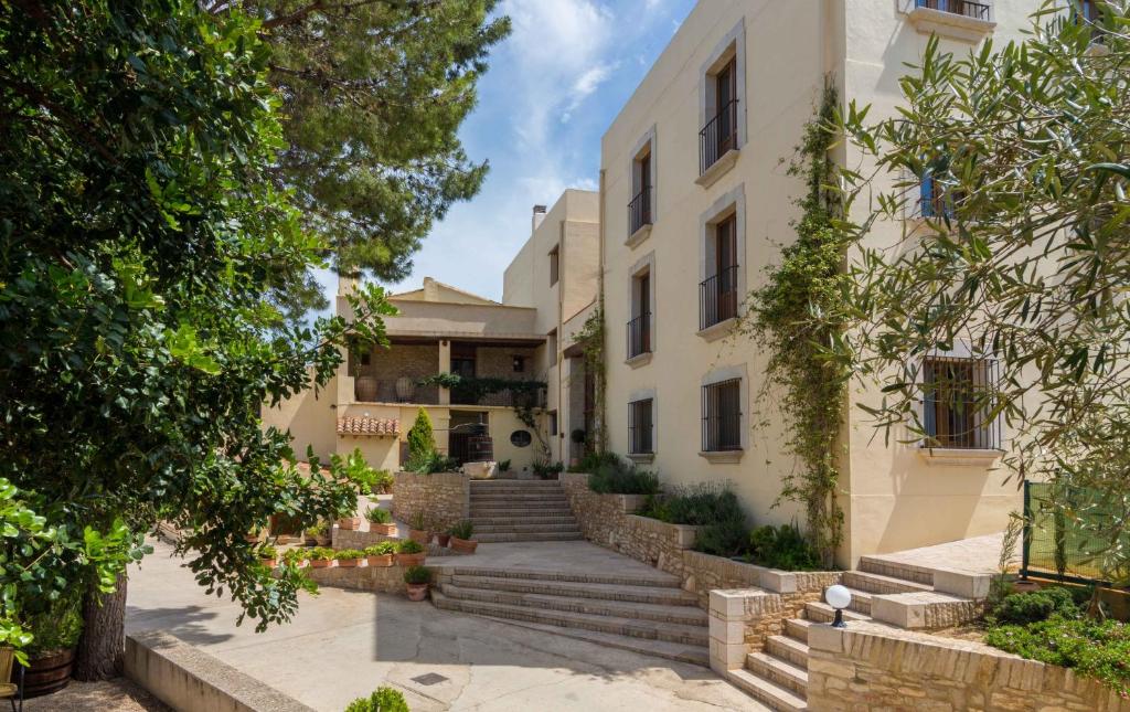 an exterior view of a building with stairs and trees at Mas dels Estellers in Sant Jordi