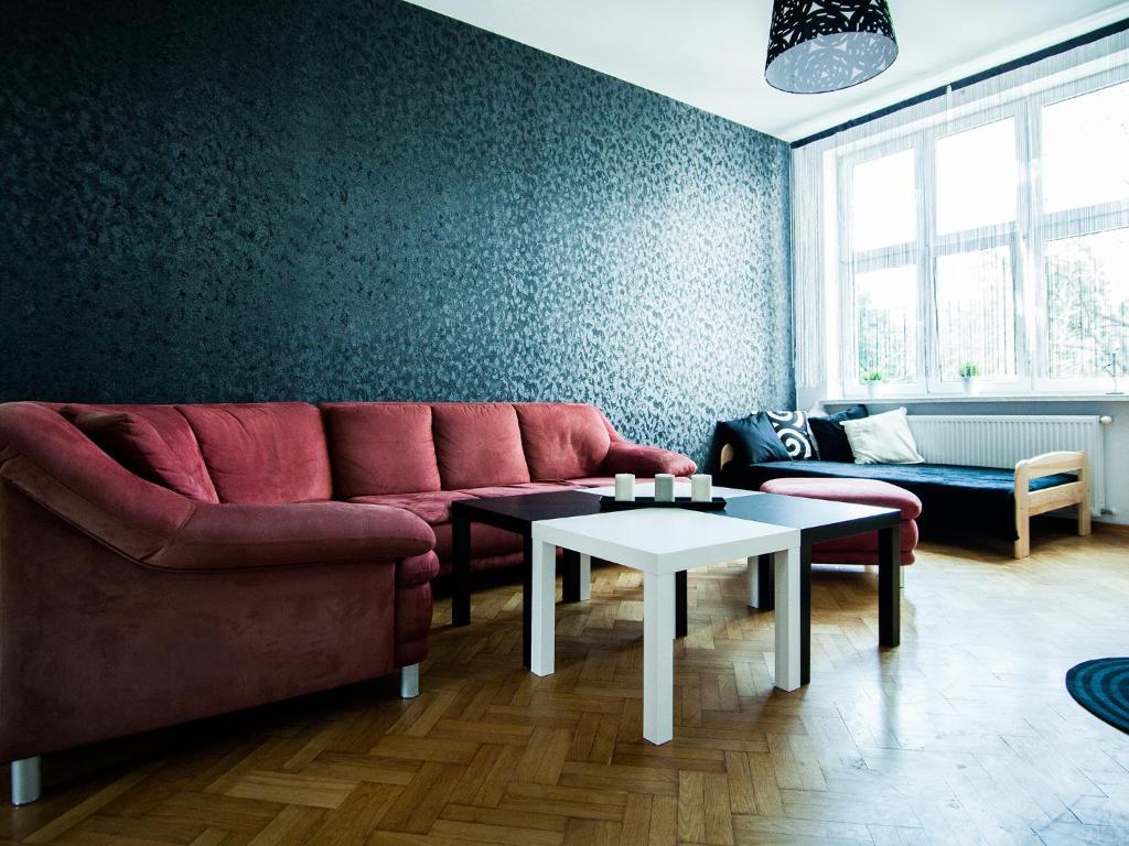 uma sala de estar com um sofá vermelho e uma mesa em Hostel 4you em Bielsko-Biala