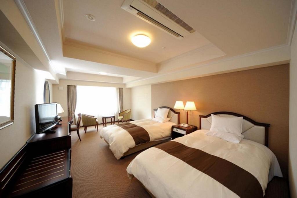 Un pat sau paturi într-o cameră la Imabari Kokusai Hotel