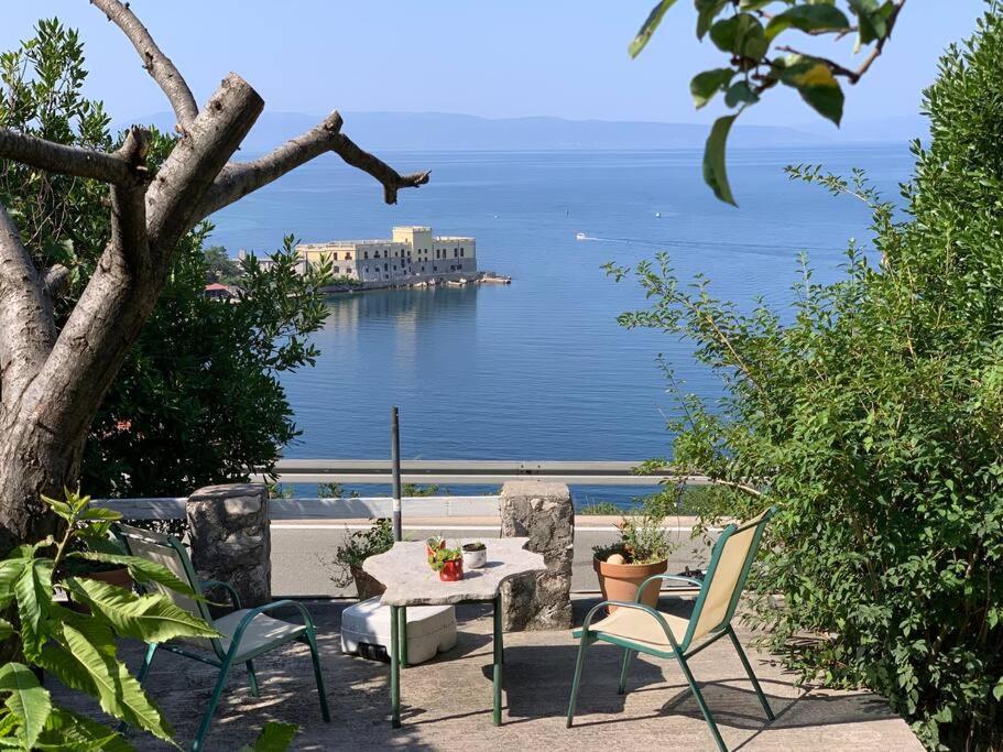 a table and chairs with a view of the water at Zeleno i plavo in Kraljevica