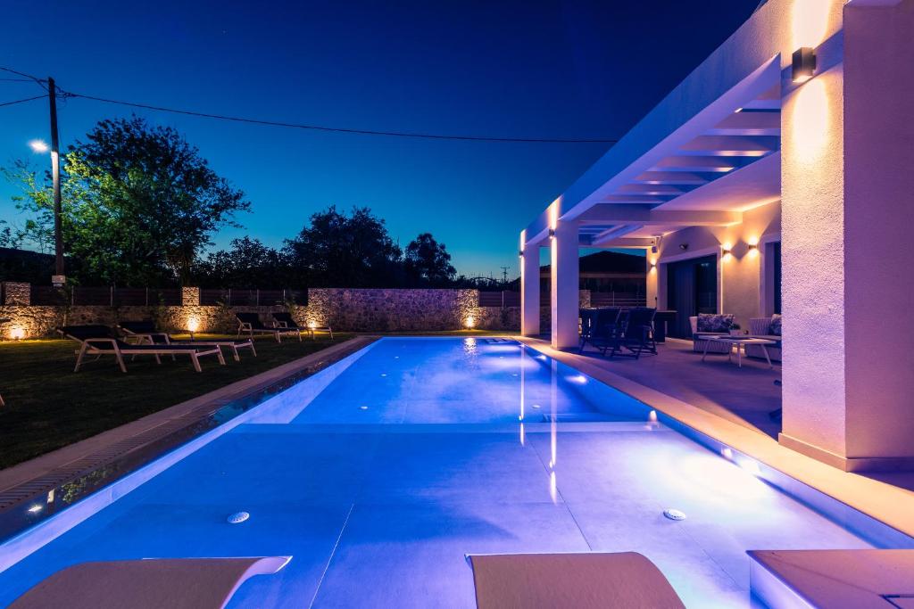 een zwembad in de achtertuin van een huis 's nachts bij Arivallos Villa & SPA with Sauna and Wine Cellar in (( Litherés ))