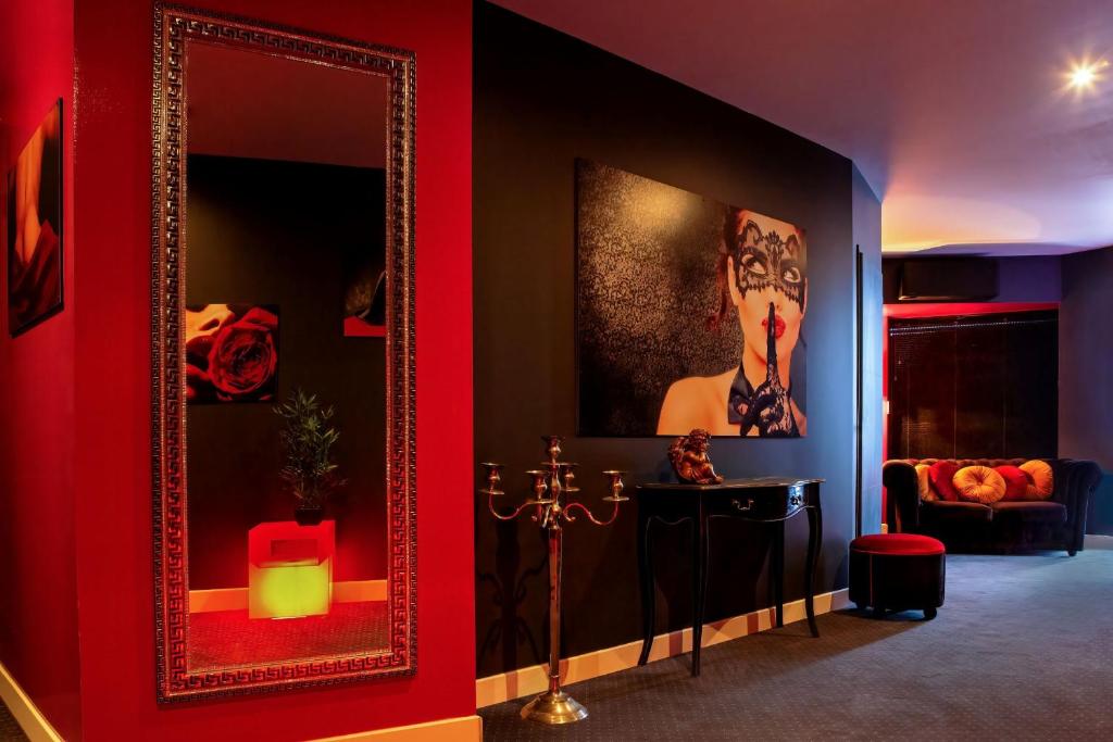 a room with a mirror and a table and a couch at SUITE PLAYROOM Love Hotel Toulouse in Toulouse