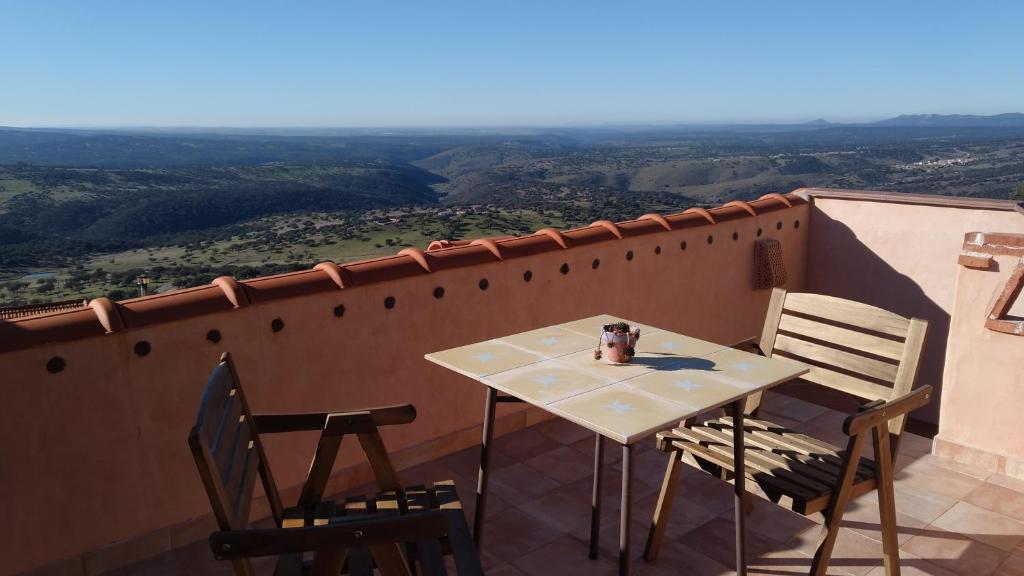 una mesa y sillas en un balcón con vistas en Apartamentos bioclimáticos El Mirlo Azul, en Cabañas del Castillo