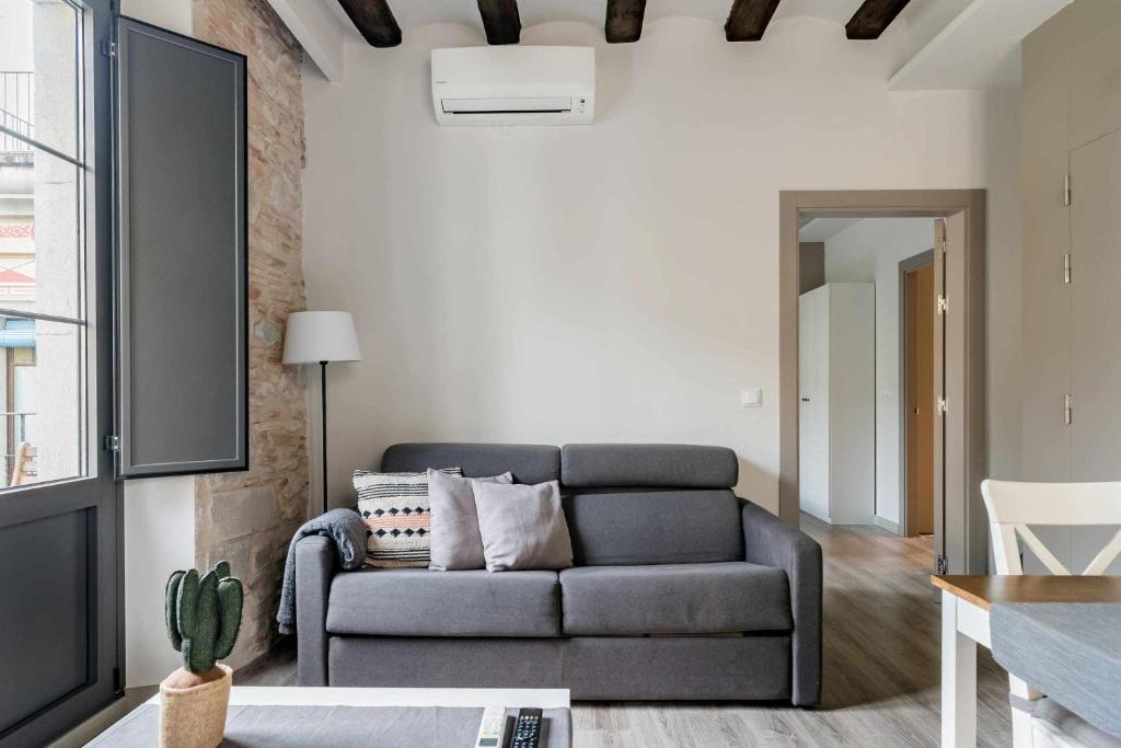 a living room with a couch and a table at Bonaventura 4 Restored Apartment in Heart of City in Girona