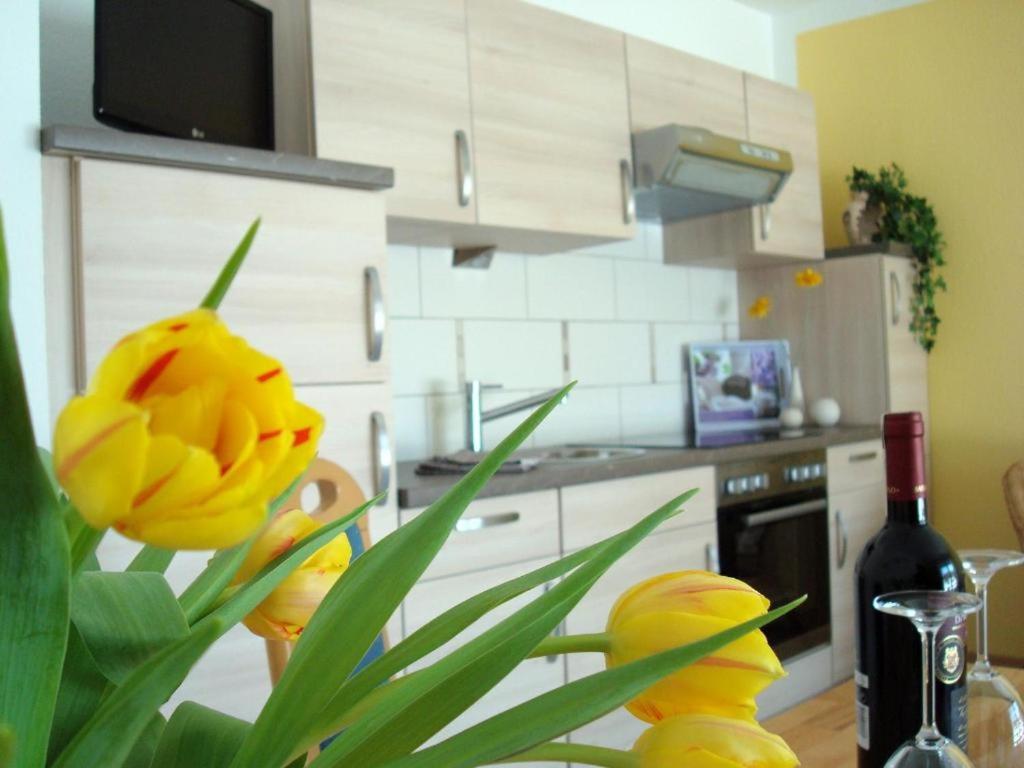 a kitchen with a yellow flower and a bottle of wine at Ferienwohnungen Heideidylle in Amelinghausen
