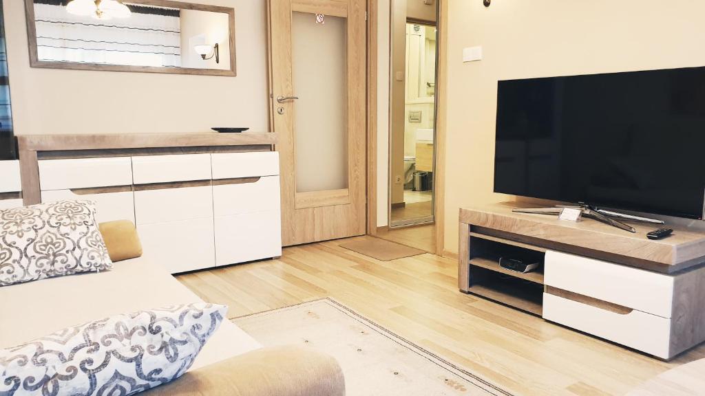 a living room with a television and a couch at Studio City centre Lutomierska Manufaktura in Łódź