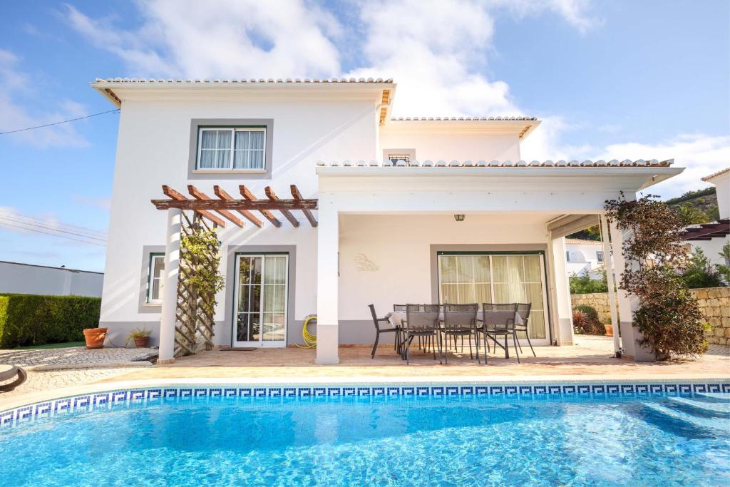 a villa with a swimming pool in front of a house at Villa Goshen in Lagos