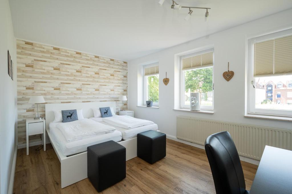 a bedroom with two beds and two windows at Hotel Neumaier in Xanten