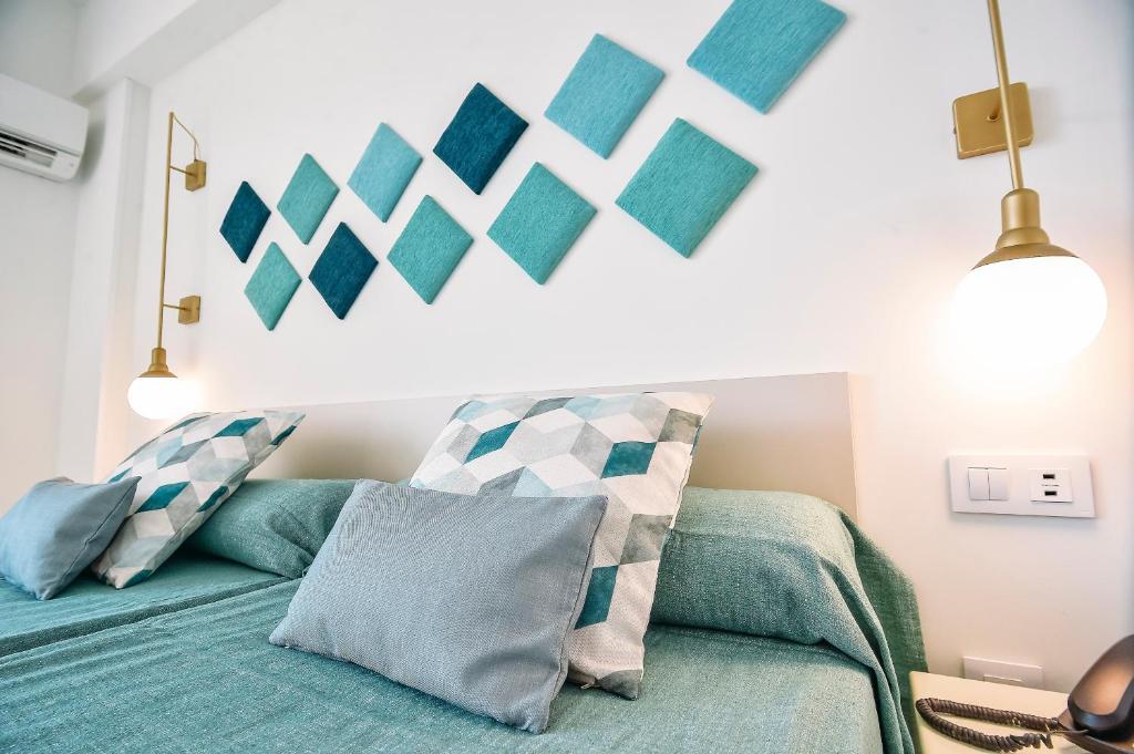 1 dormitorio con 1 cama con sábanas y almohadas azules en Hotel Gala Placidia 3'''sup, en Benidorm