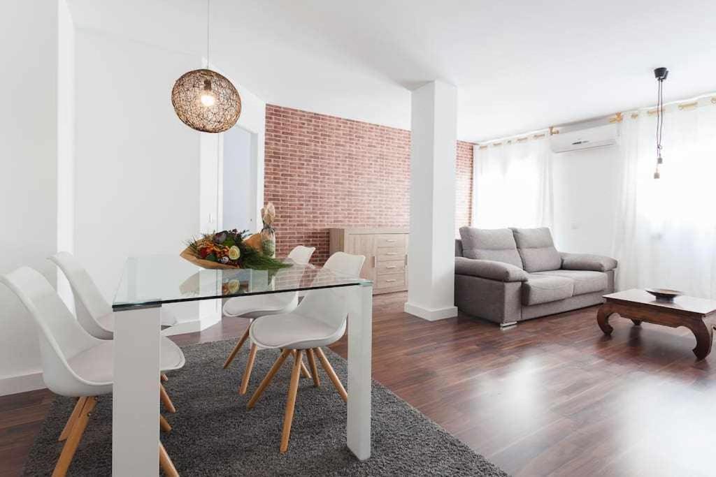 uma sala de estar com uma mesa e cadeiras e um sofá em Apartamento para 4 con terraza privada en el centro em Girona