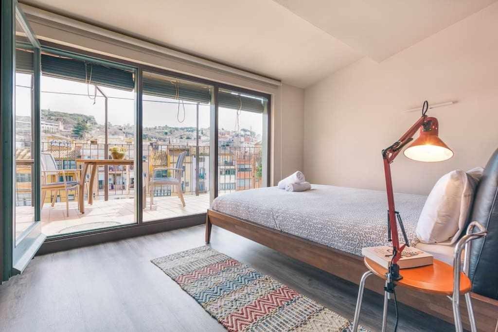 ジローナにあるSleep y Stay Luxury top floor apt with terraceのベッドルーム(ランプ付きのベッド1台、バルコニー付)