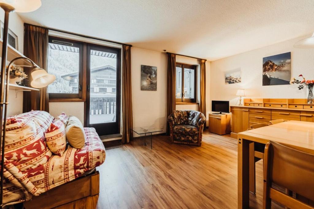 Cette chambre comprend un lit, un bureau et une cuisine. dans l'établissement Liarets Furnished flat, à Chamonix-Mont-Blanc