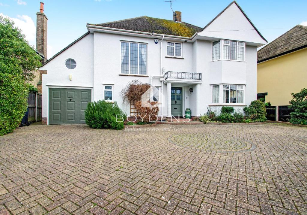 a large white house with a driveway at The Avenues, Frinton on Sea in Frinton-on-Sea