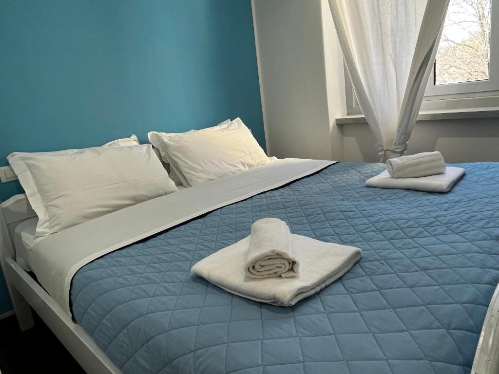 a bed with towels on top of it with a window at Villa Tergeste in Trieste