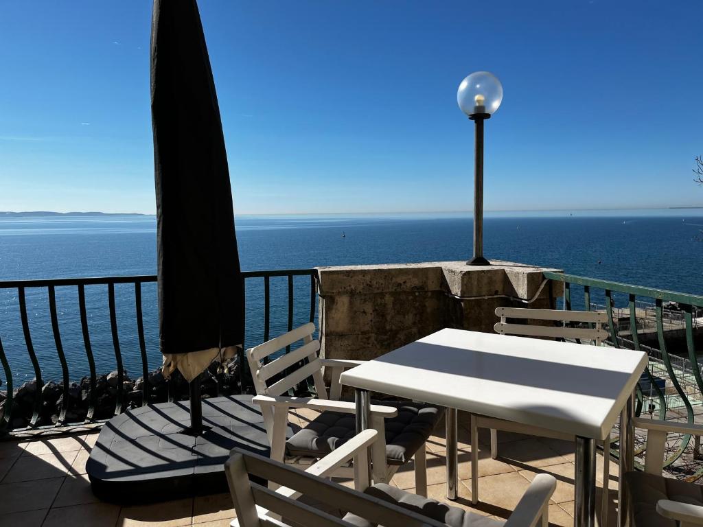 a table and chairs with a view of the ocean at Villa Tergeste in Trieste