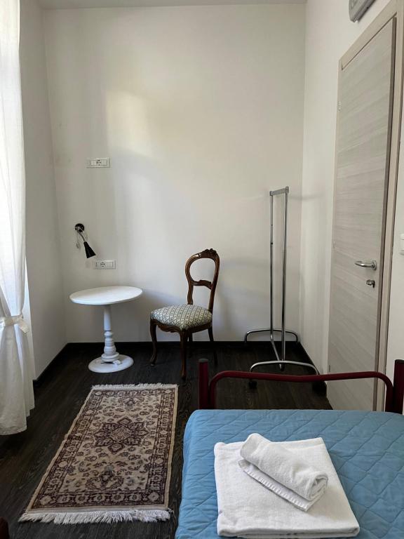 a bedroom with a bed and a table and a chair at Villa Tergeste in Trieste
