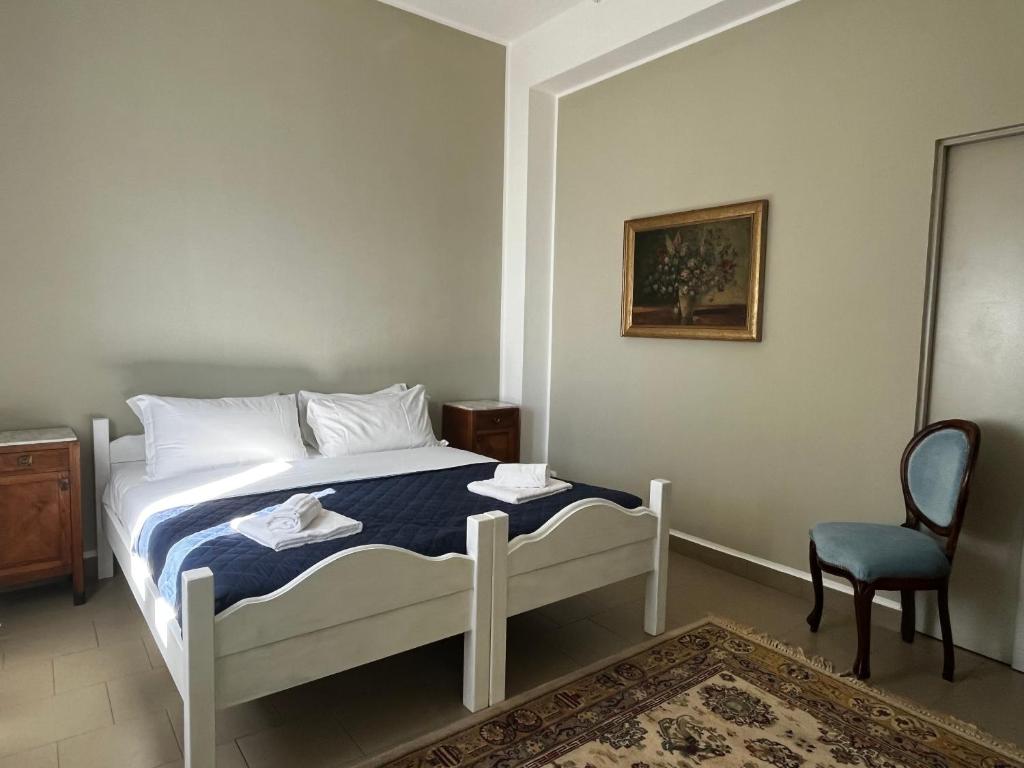 a bed in a room with a chair and a bed sidx sidx sidx at Villa Tergeste in Trieste