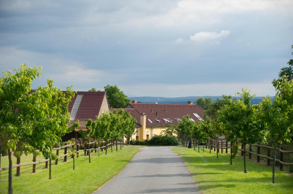 einen Weg durch ein Dorf mit Bäumen und Häusern in der Unterkunft Farma Moulisových in Nezvěstice