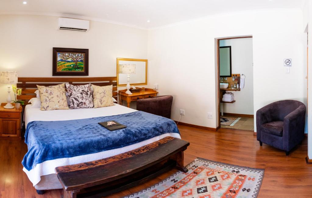 a bedroom with a bed and a chair at 37 on Charles in Pretoria