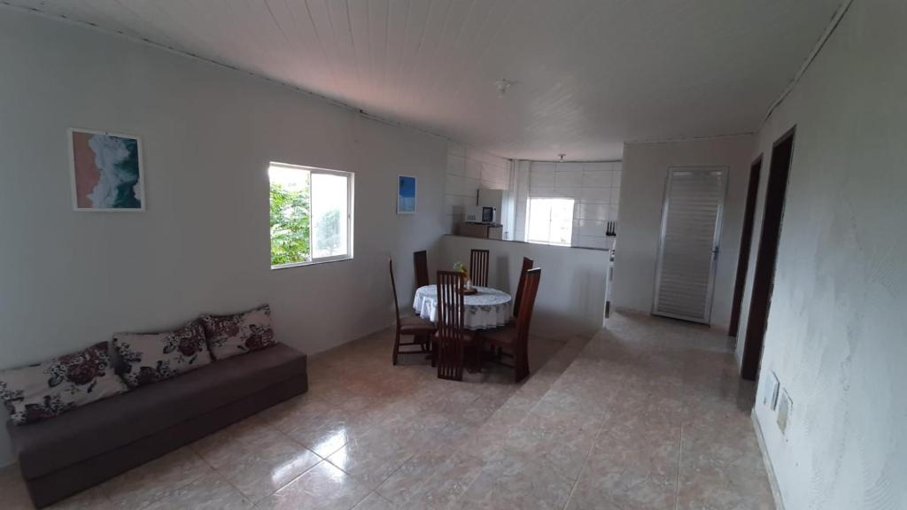 a living room with a couch and a table at 3º andar independente - Casa a 50m da praia com vista lateral para o mar in Saquarema