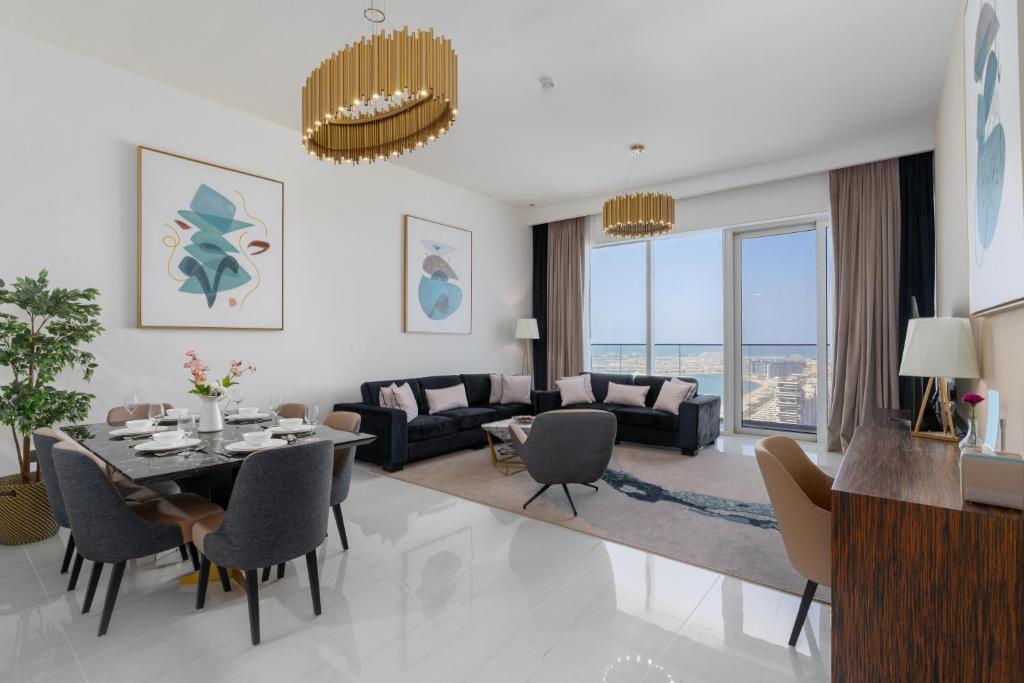 Una sala de estar con una mesa y sillas y un sofá. en ON OFF HH-AVANI HOTEL-3BR -Full Palm View, en Dubái