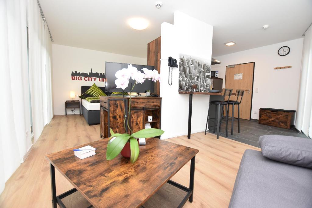 a living room with a wooden table with a plant on it at Boardinghouse Henschelstraße in Munich