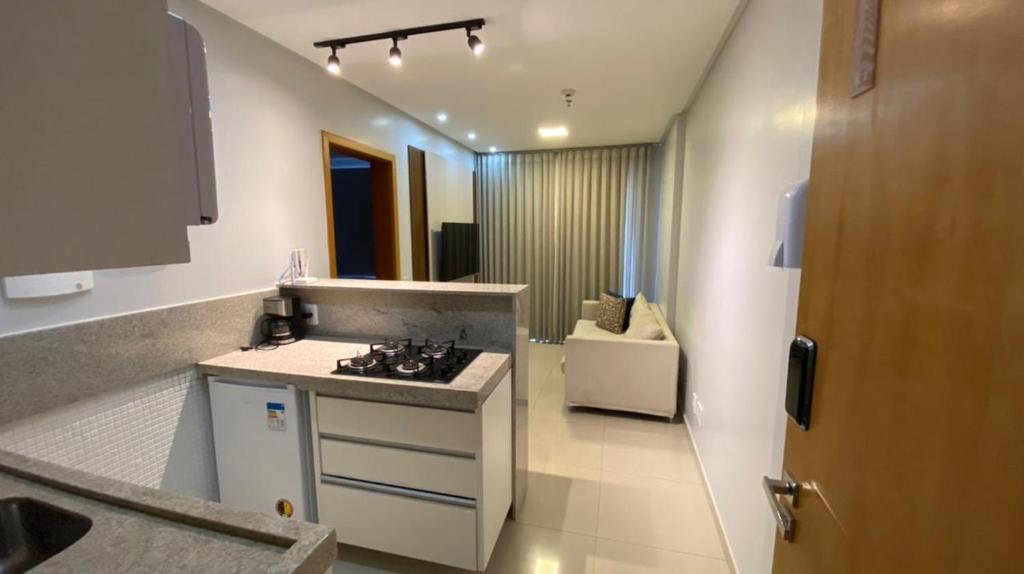 uma cozinha com um lavatório e uma bancada em Flat Essenciale Style1602 em Goiânia