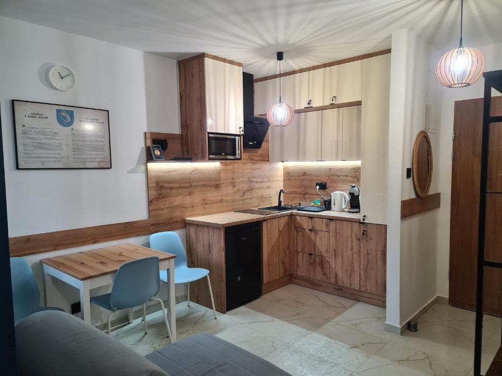 a kitchen with wooden cabinets and a table and chairs at Apartament Króla Sielaw - Mikołajki in Mikołajki