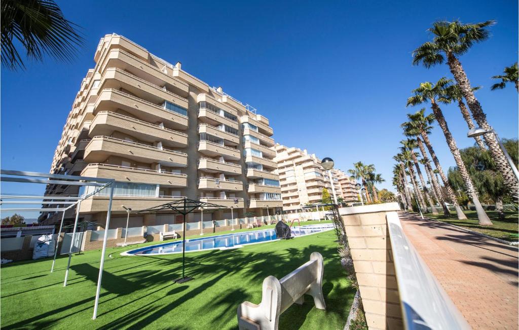 a large apartment building with a swimming pool and palm trees at Beautiful Apartment In Orpesa Del Mar in Oropesa del Mar