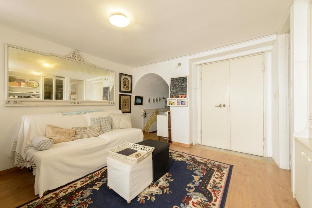 ein Wohnzimmer mit einem weißen Sofa und einem großen Fenster in der Unterkunft Giardino Segreto in Neapel