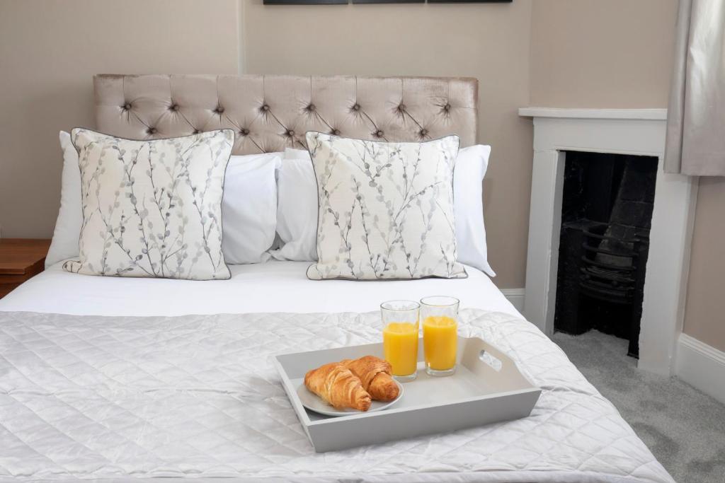 
a bed with a tray of fruit on top of it at 2 Bedroom High Street Duplex Apartment in Cheltenham
