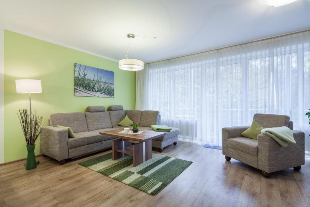 - un salon avec un canapé, des chaises et une table dans l'établissement Residenz Seestern Wohnung 22, à Boltenhagen