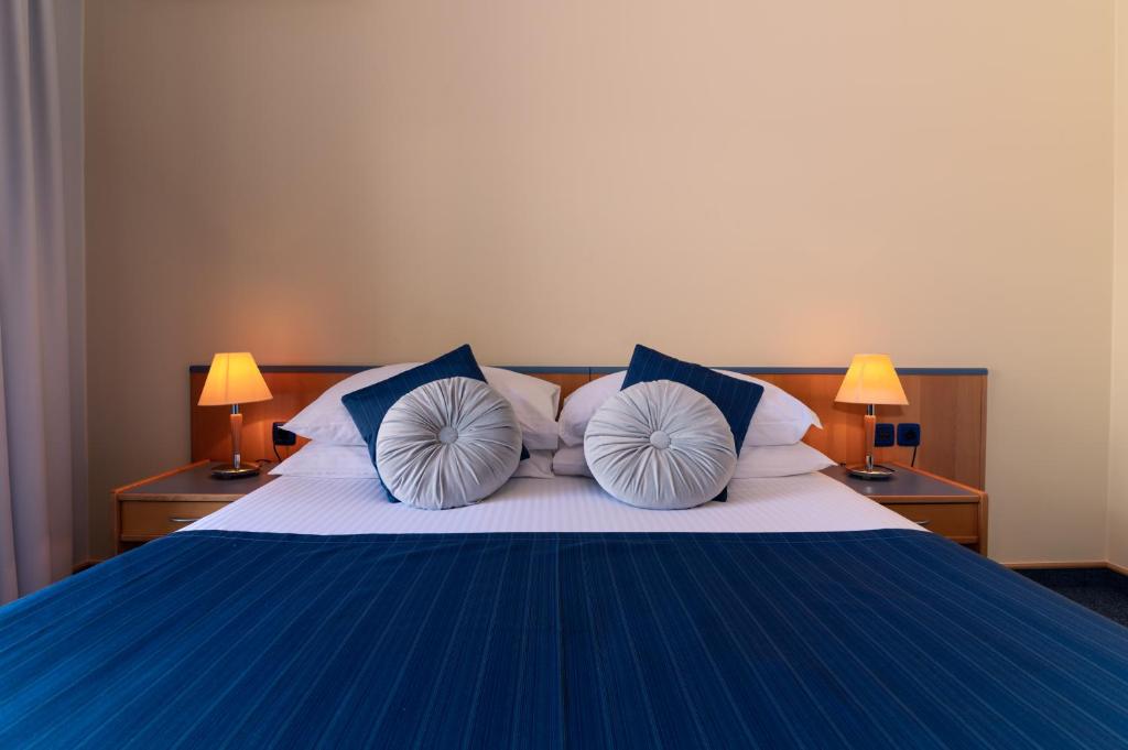 Un dormitorio con una cama azul y blanca con almohadas en Guest Accomodation Tamaris, en Zadar