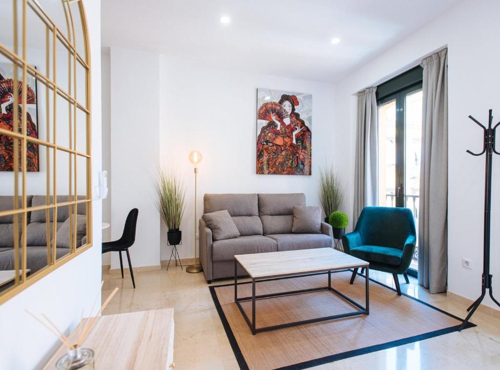salon z kanapą i stołem w obiekcie Guardamino Dúplex Suite Apartment w Sewilli