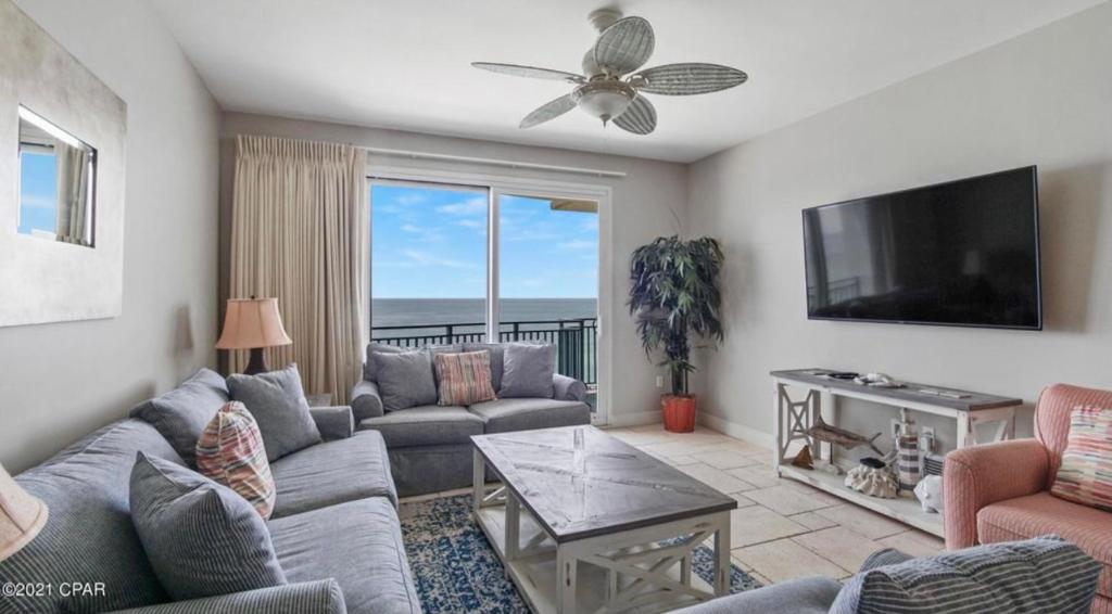 a living room with a couch and a flat screen tv at Sterling Breeze 1007 in Panama City Beach