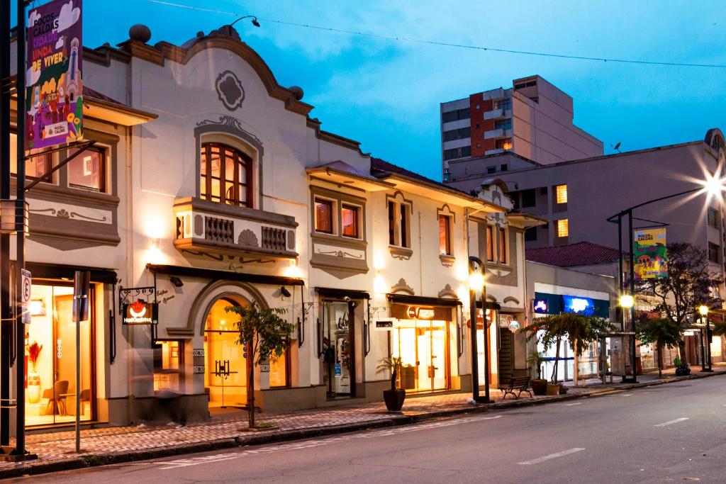 een straat in een stad 's nachts met gebouwen bij Hotel Gambrinus in Poços de Caldas
