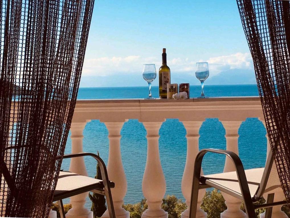 uma vista para o oceano a partir de uma varanda com copos de vinho em Vasilakis Home Fantasy Balcony Apraos em Apraos