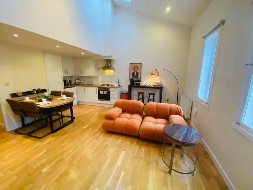 a living room with a couch and a table and a kitchen at 2 Bed 2 bath with Private Parking in Edinburgh